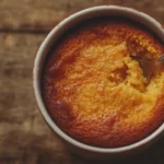 Warm microwavable pumpkin dessert mug cake with a spoon.